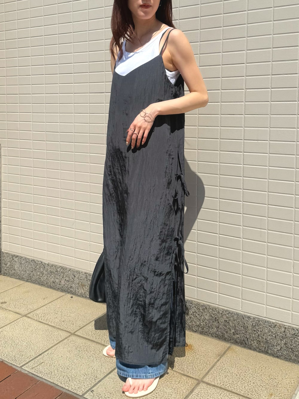 ブラック系のワンピース、ホワイト系のタンクトップを着用したレディースの春コーディネートの2枚目の写真