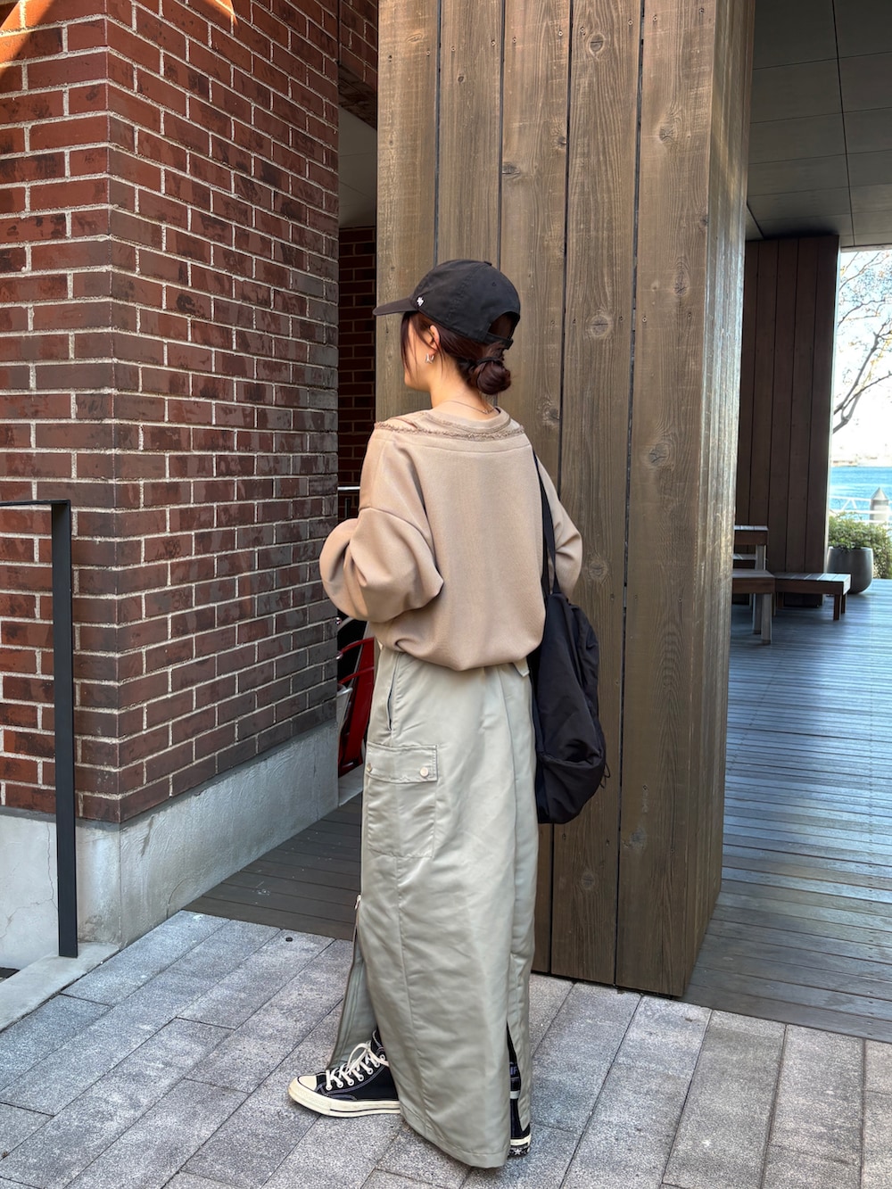 グリーン系のスカート、ブラウン系のTシャツ/カットソーを着用したレディースの冬コーディネートの3枚目の写真