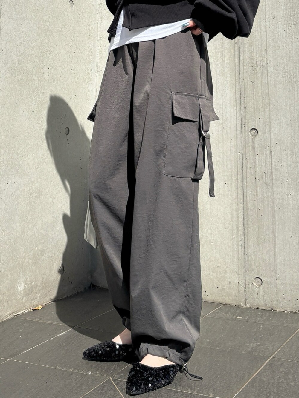 ブラック系のカーディガン/ボレロ、ブラック系のカーゴパンツ、ホワイト系のタンクトップを着用したレディースの春コーディネートの2枚目の写真