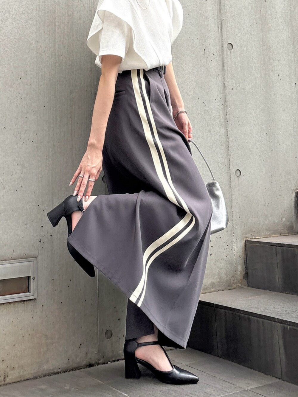 グレー系のスカート、ホワイト系のTシャツ/カットソーを着用したレディースの夏コーディネートの2枚目の写真