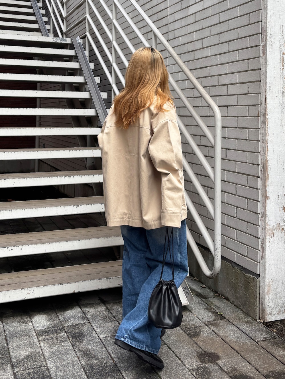 ベージュ系のブルゾン、ホワイト系のTシャツ/カットソー、ブルー系のデニムパンツを着用したレディースの春コーディネートの2枚目の写真