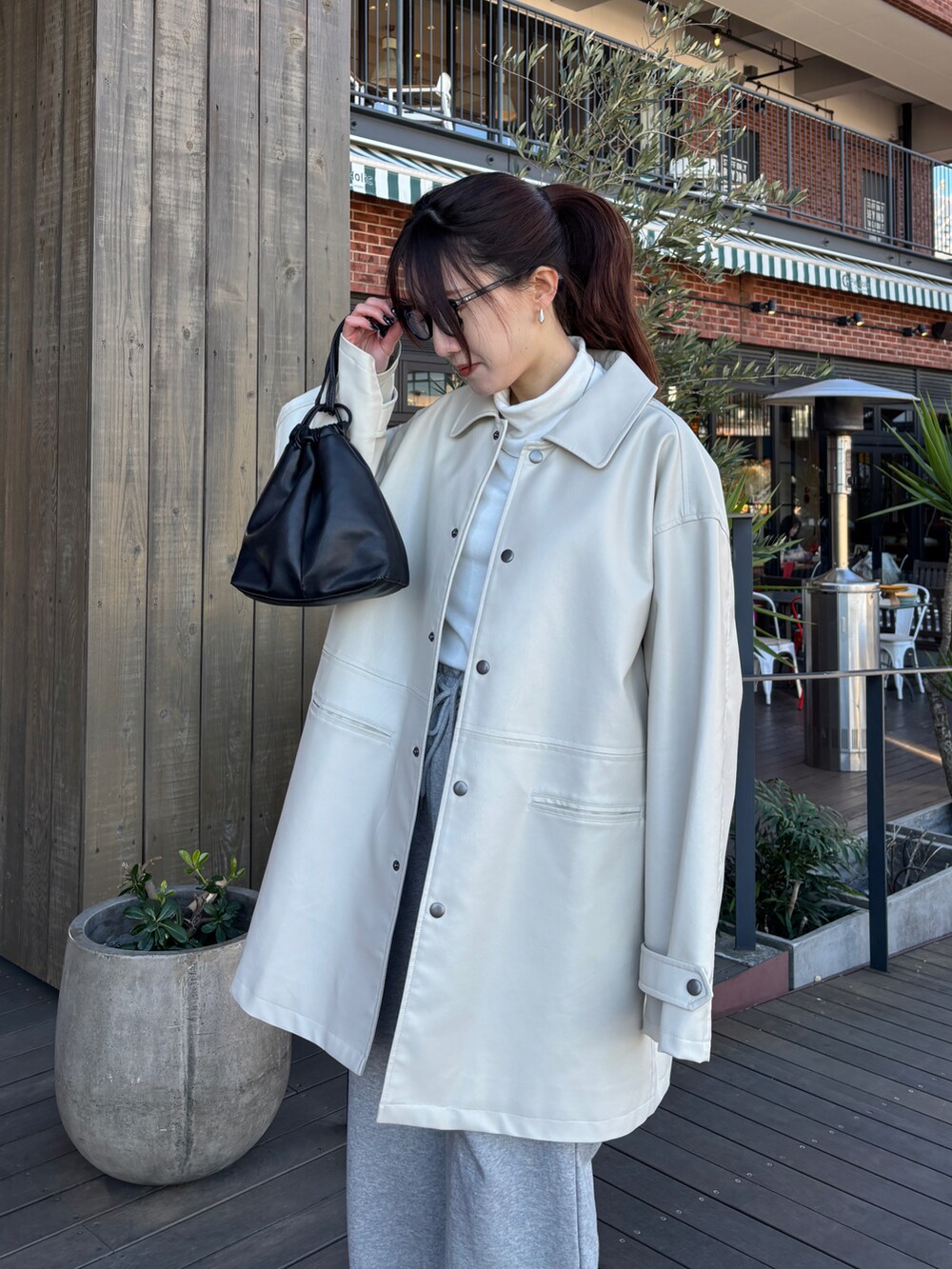 ホワイト系のブルゾン、グレー系のスウェットパンツを着用したレディースの冬コーディネートの2枚目の写真