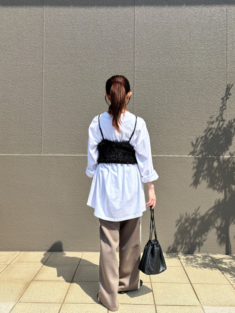 ブラック系のキャミソール、ホワイト系のTシャツ/カットソー、ブラウン系のその他パンツを着用したレディースの春コーディネートの2枚目の写真