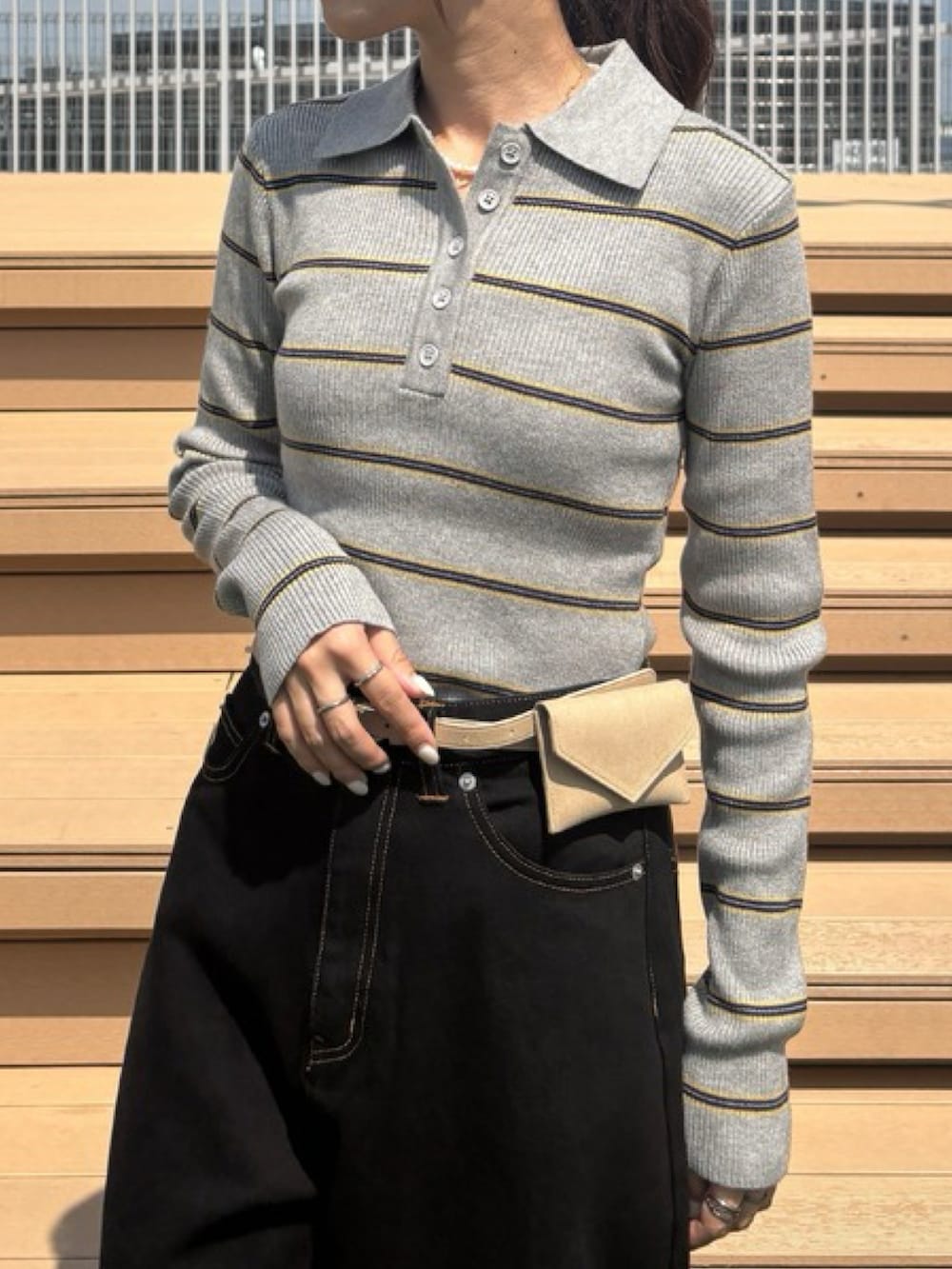 ブラック系のデニムパンツ、グレー系のニット/セーター、ブラック系のスニーカーを着用したレディースの秋コーディネートの2枚目の写真