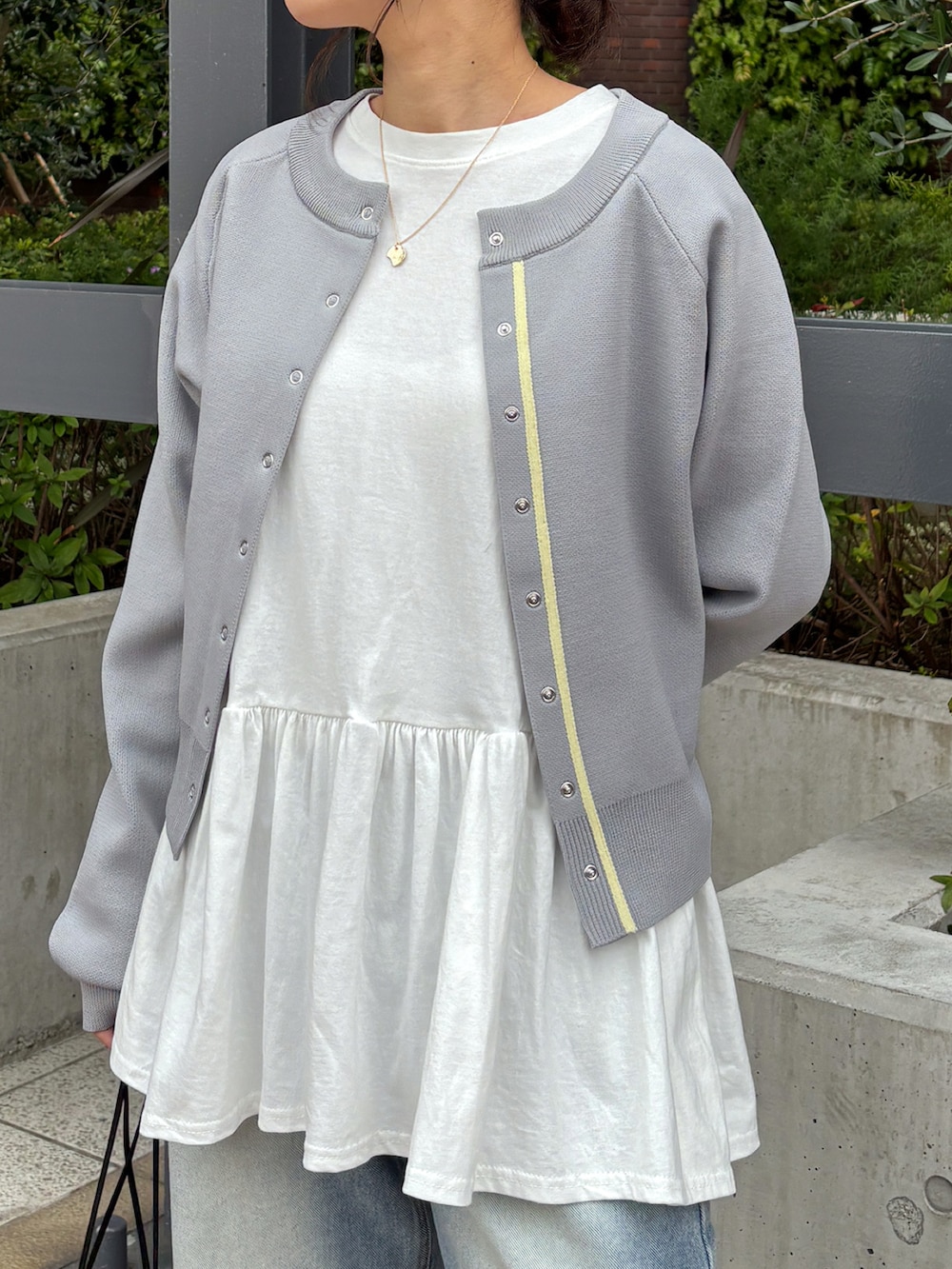 ホワイト系のTシャツ/カットソー、グレー系のカーディガン/ボレロ、ブルー系のデニムパンツを着用したレディースの春コーディネートの3枚目の写真