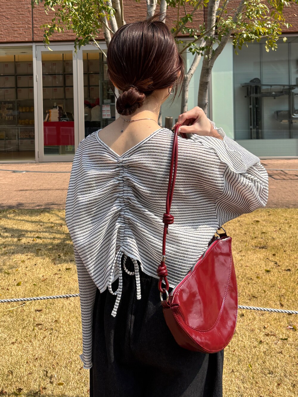 ホワイト系のTシャツ/カットソー、レッド系のハンドバッグ、ブラック系のデニムパンツを着用したレディースの春コーディネートの3枚目の写真