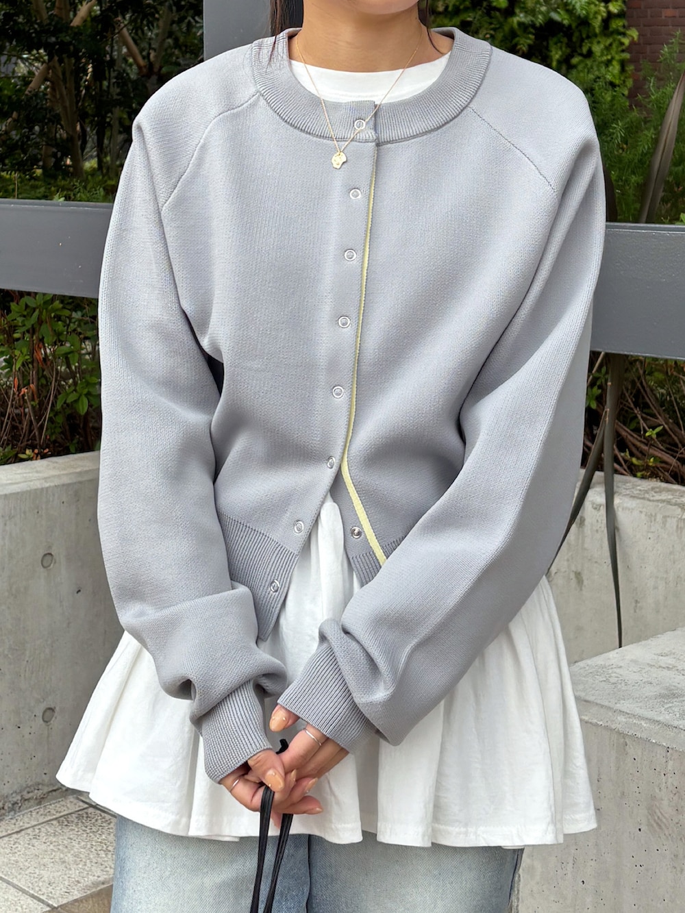 ホワイト系のTシャツ/カットソー、グレー系のカーディガン/ボレロ、ブルー系のデニムパンツを着用したレディースの春コーディネートの2枚目の写真