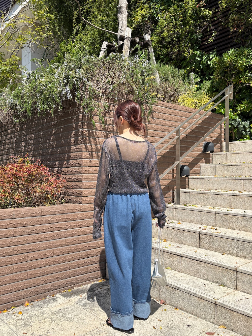 ブルー系のデニムパンツ、ブラック系のTシャツ/カットソーを着用したレディースの春コーディネートの3枚目の写真