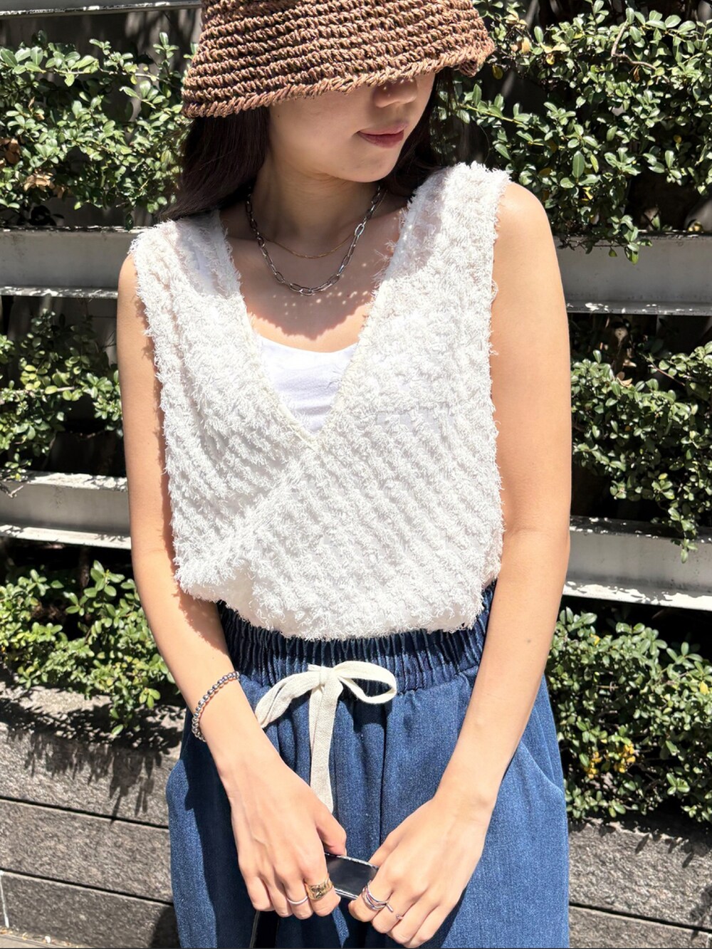 ブルー系のデニムパンツ、ブラック系のタンクトップを着用したレディースの春コーディネートの2枚目の写真