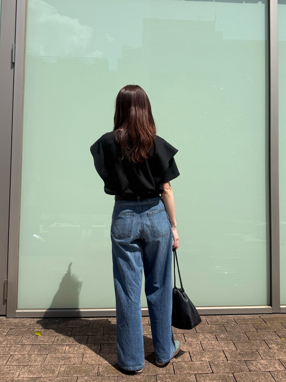 ブラック系のTシャツ/カットソーを着用したレディースの春コーディネートの4枚目の写真