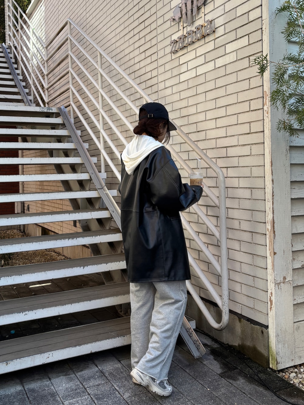 グレー系のスウェットパンツ、ホワイト系のブルゾンを着用したレディースの冬コーディネートの3枚目の写真