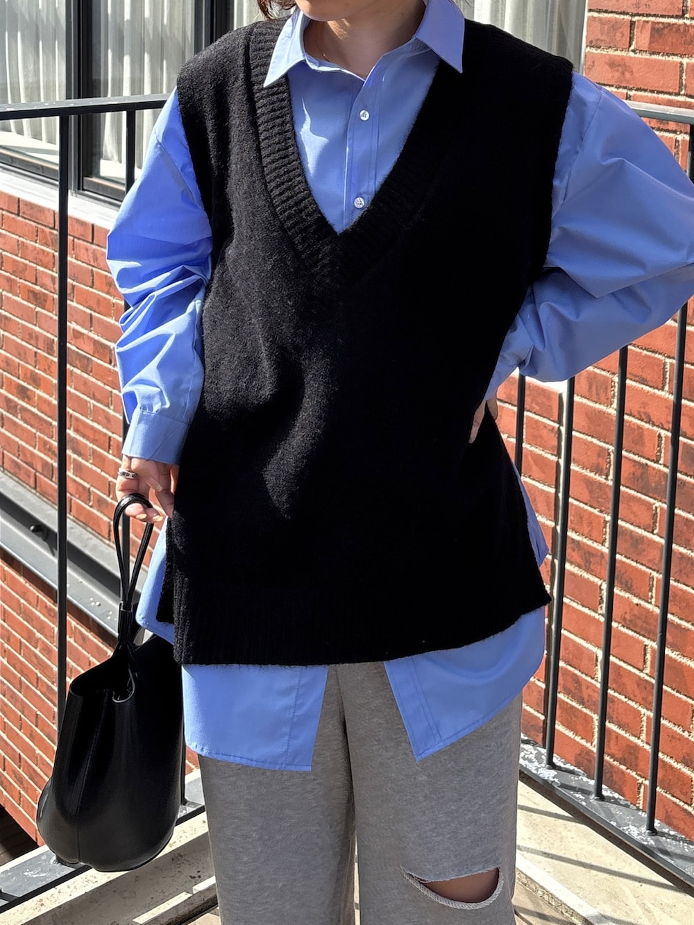 ブルー系のシャツ/ブラウス、ブラック系のベスト、グレー系のスウェットパンツを着用したレディースの冬コーディネートの2枚目の写真