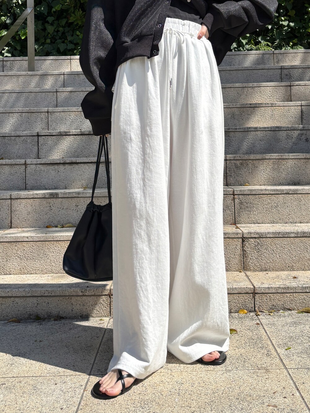 ブラック系のカーディガン/ボレロ、ホワイト系のスウェットパンツを着用したレディースの春コーディネートの3枚目の写真