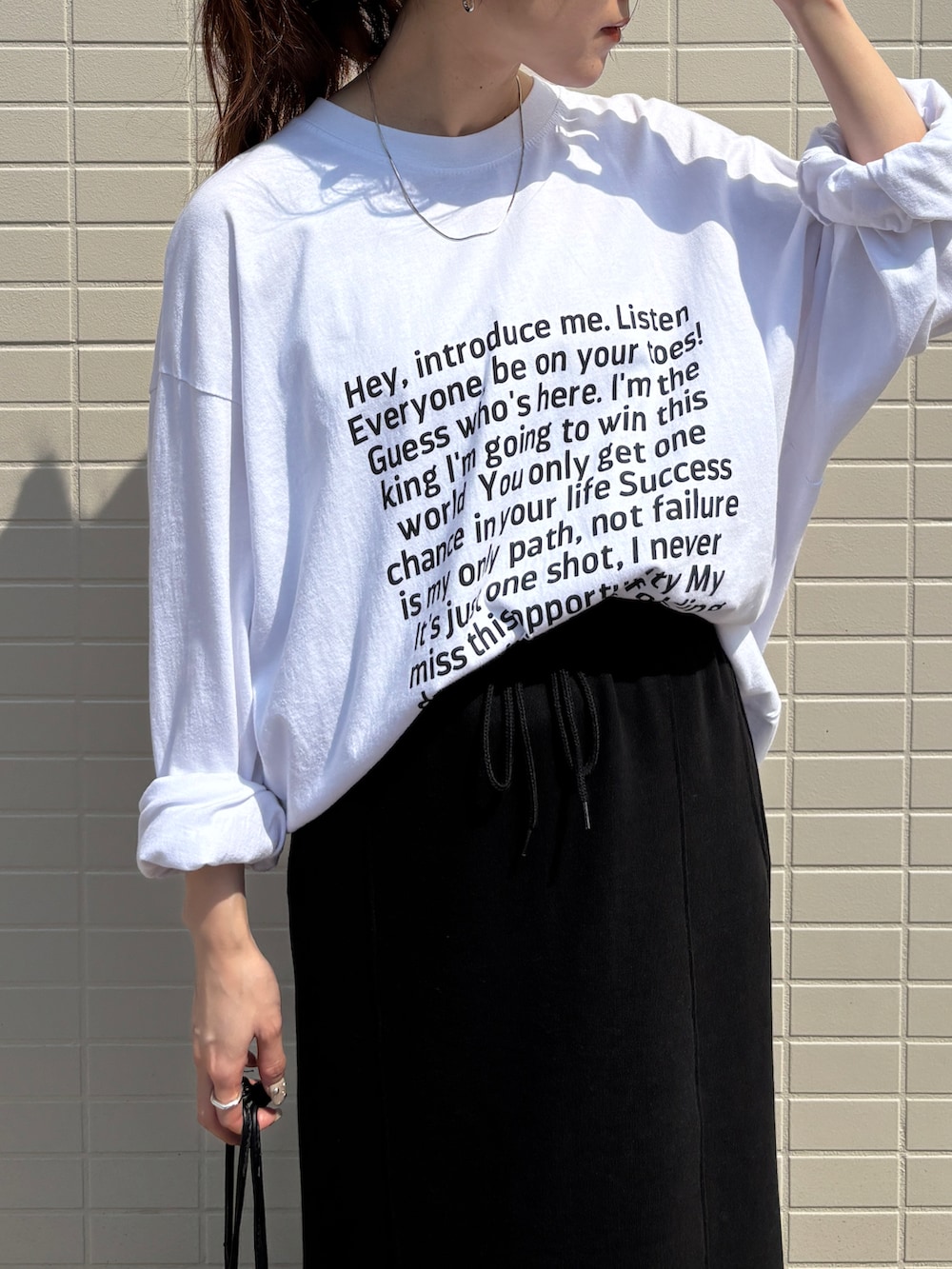 ホワイト系のTシャツ/カットソー、ブラック系のスカートを着用したレディースの春コーディネートの2枚目の写真