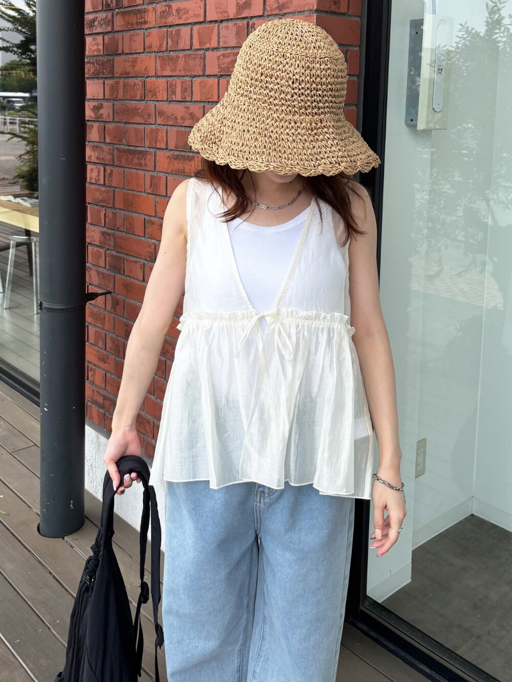 ホワイト系のシャツ/ブラウス、ブルー系のデニムパンツ、ベージュ系のハットを着用したレディースの夏コーディネートの3枚目の写真