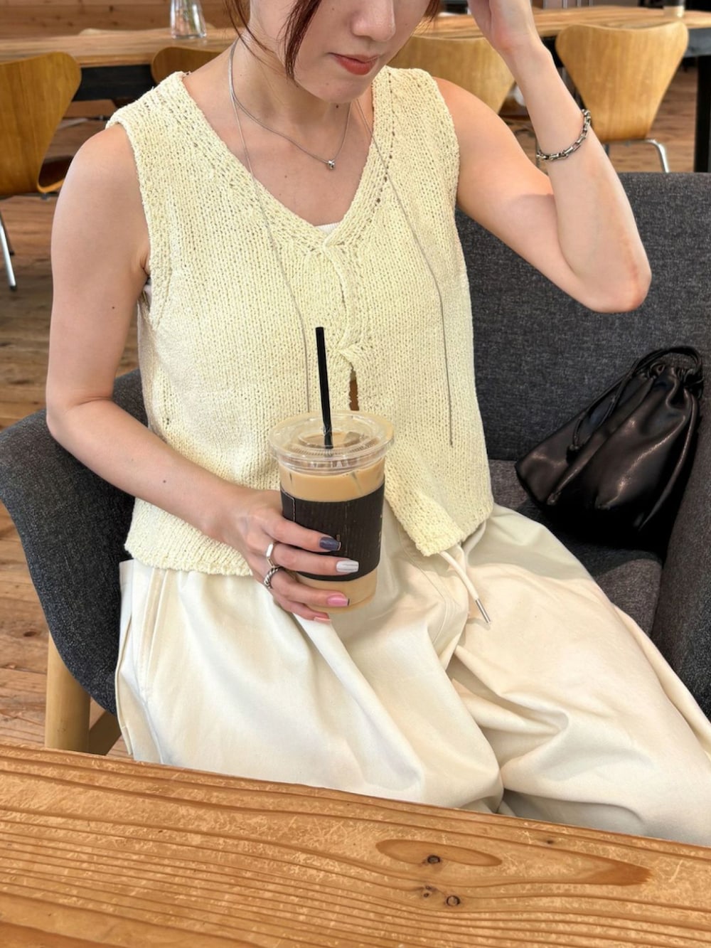 イエロー系のベスト、ホワイト系のチノパンツを着用したレディースの秋コーディネートの2枚目の写真