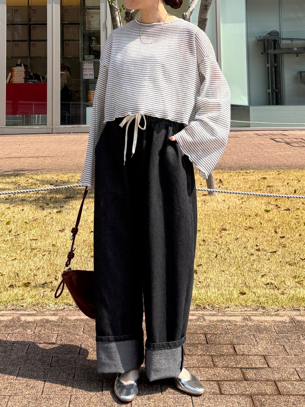 ホワイト系のTシャツ/カットソー、レッド系のハンドバッグ、ブラック系のデニムパンツを着用したレディースの春コーディネートの2枚目の写真