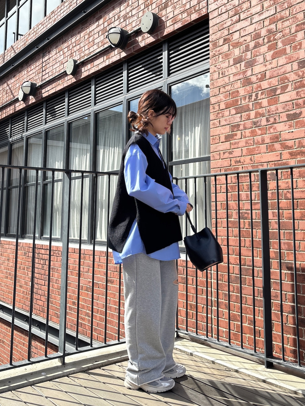 ブルー系のシャツ/ブラウス、ブラック系のベスト、グレー系のスウェットパンツを着用したレディースの冬コーディネートの3枚目の写真