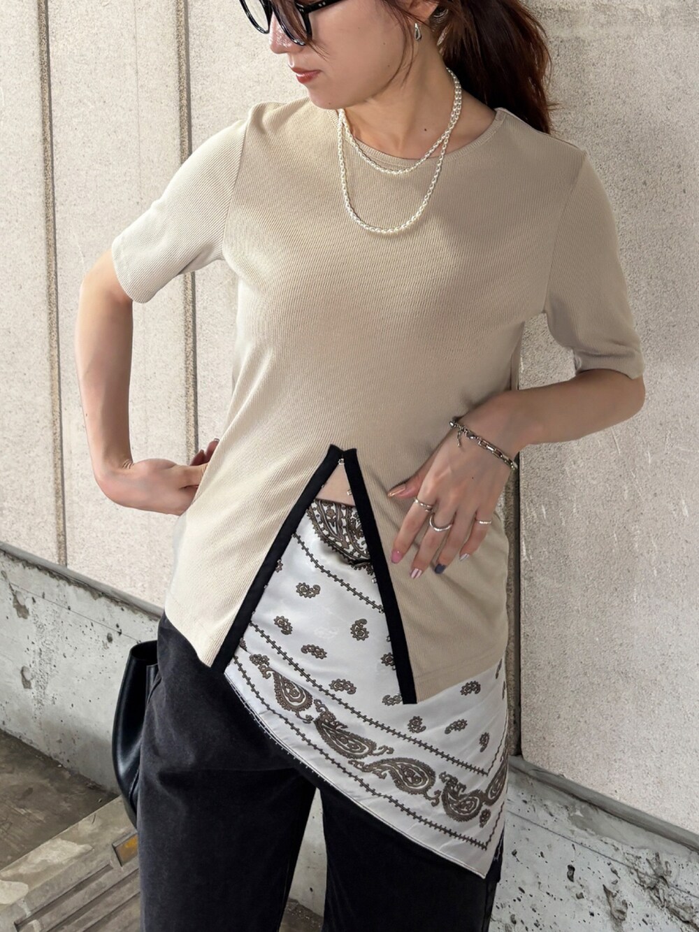 ベージュ系のTシャツ/カットソー、ブラック系のデニムパンツ、ブラック系のスニーカーを着用したレディースの秋コーディネートの2枚目の写真