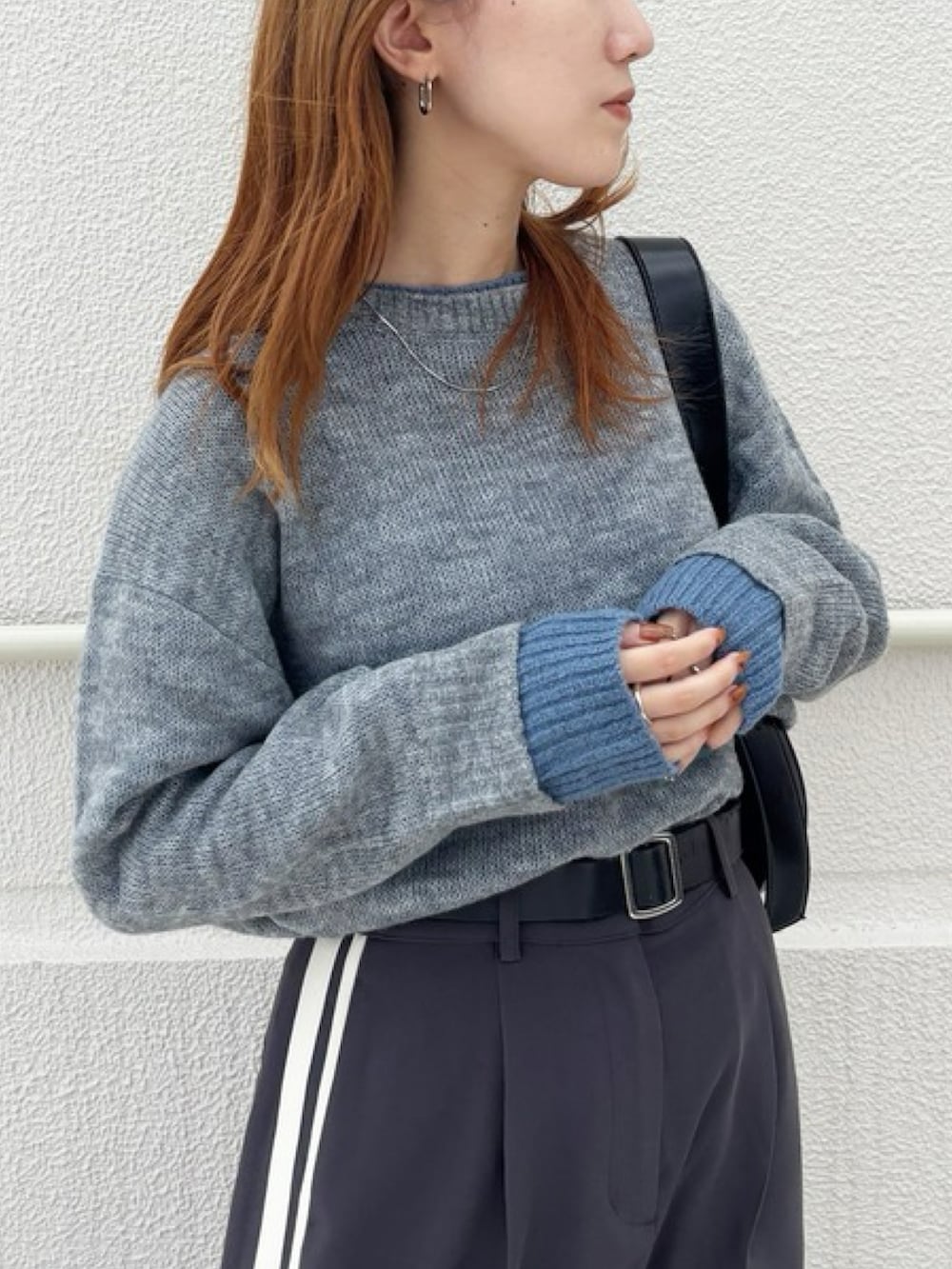 グレー系のニット/セーター、グレー系のスカートを着用したレディースの秋コーディネートの2枚目の写真