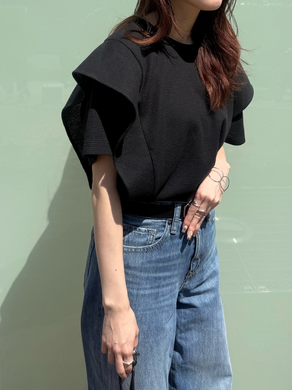 ブラック系のTシャツ/カットソーを着用したレディースの春コーディネートの2枚目の写真