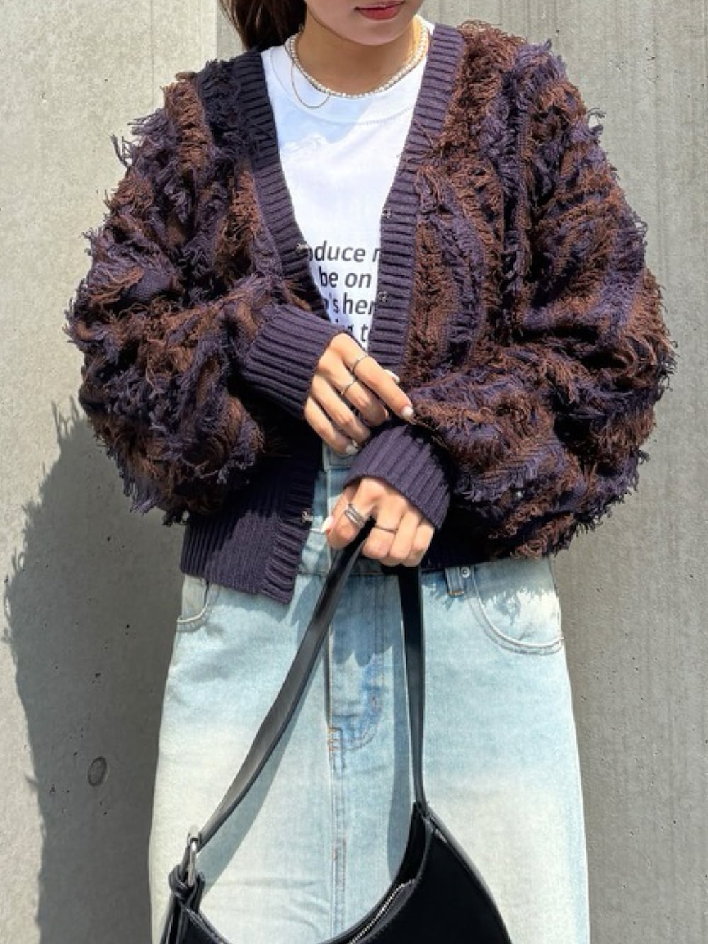 ブルー系のニット/セーター、ブルー系のデニムスカート、ブラック系のスニーカーを着用したレディースの秋コーディネートの2枚目の写真