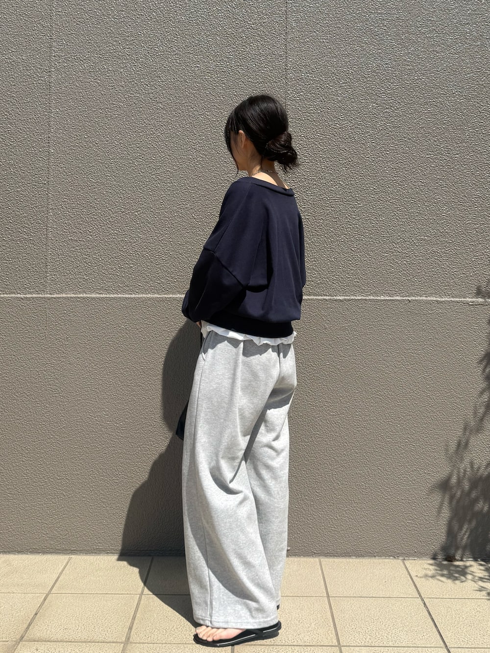 グレー系のスウェットパンツ、ブルー系のカーディガン/ボレロ、ホワイト系のチュニックを着用したレディースの春コーディネートの3枚目の写真