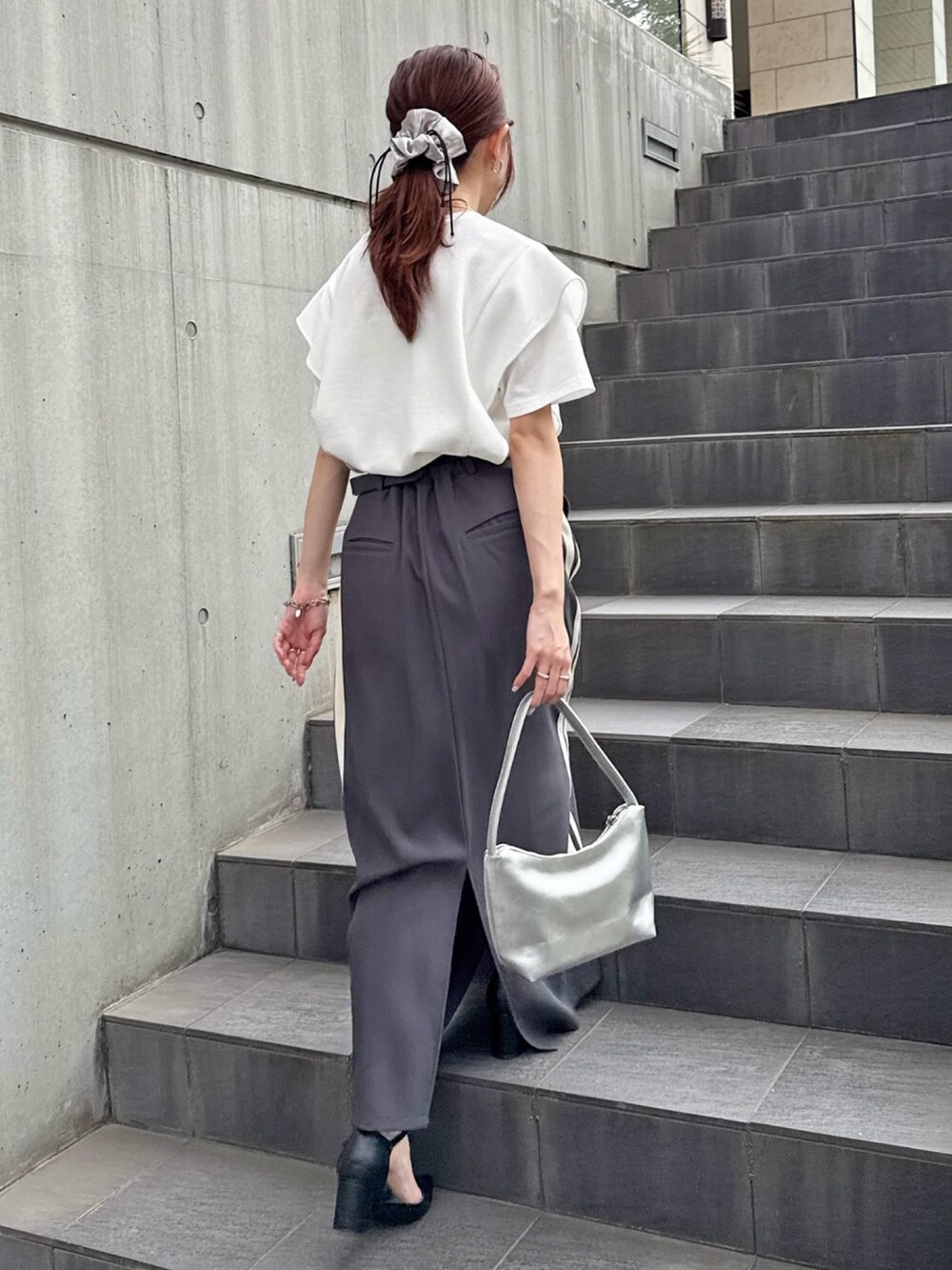 グレー系のスカート、ホワイト系のTシャツ/カットソーを着用したレディースの夏コーディネートの3枚目の写真