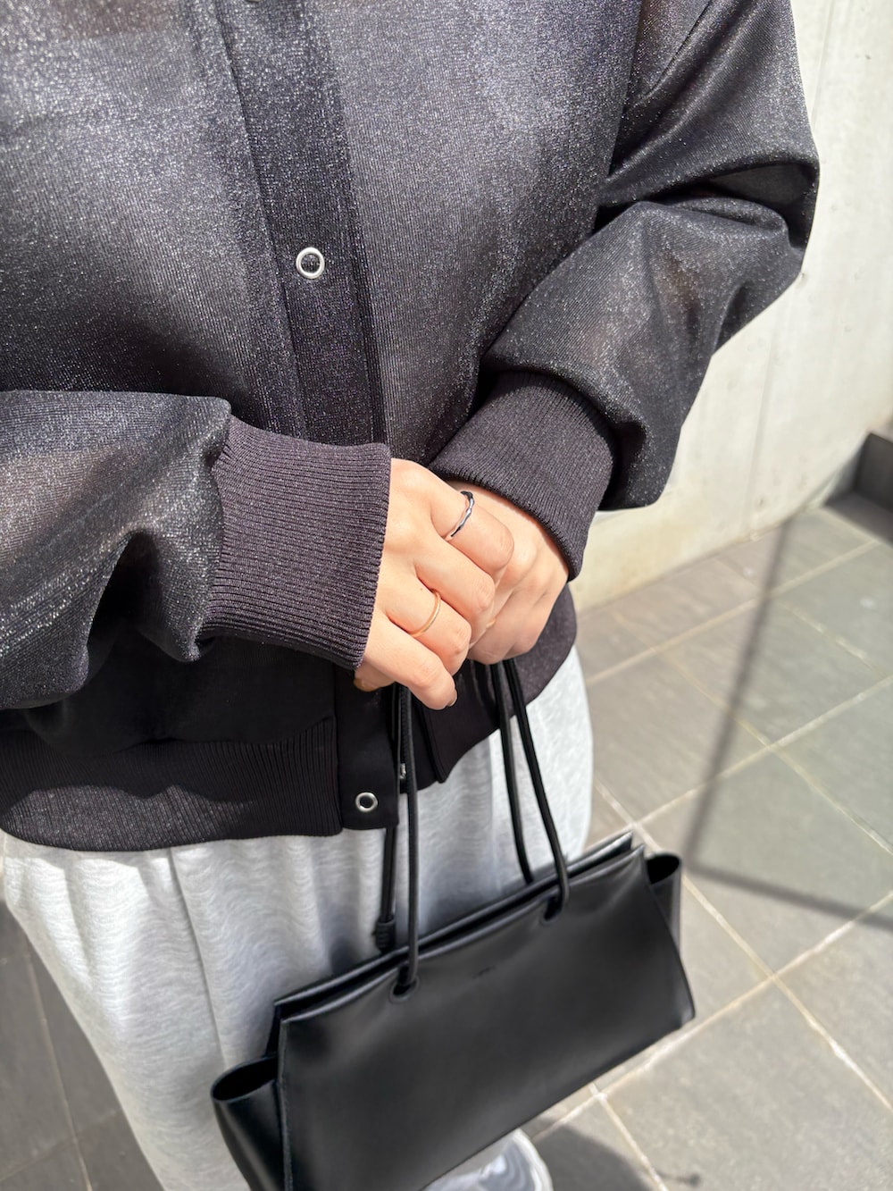 ブラック系のカーディガン/ボレロ、グレー系のスウェットパンツを着用したレディースの春コーディネートの2枚目の写真