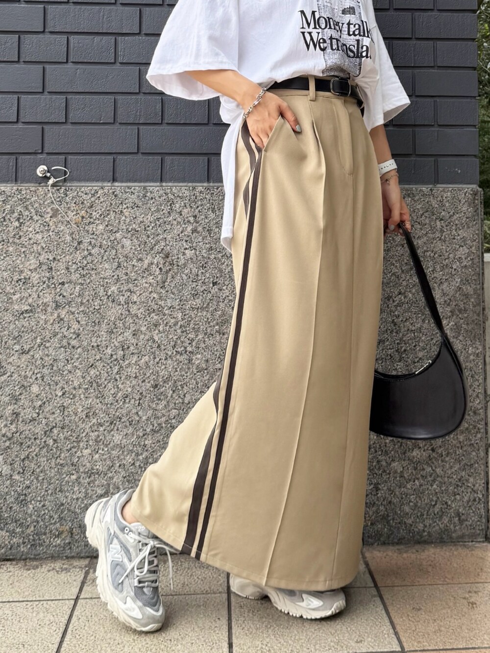 ベージュ系のスカート、ホワイト系のTシャツ/カットソーを着用したレディースの夏コーディネートの2枚目の写真