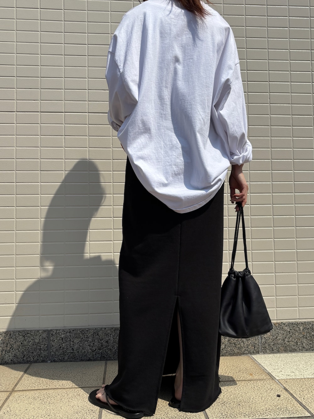 ホワイト系のTシャツ/カットソー、ブラック系のスカートを着用したレディースの春コーディネートの3枚目の写真
