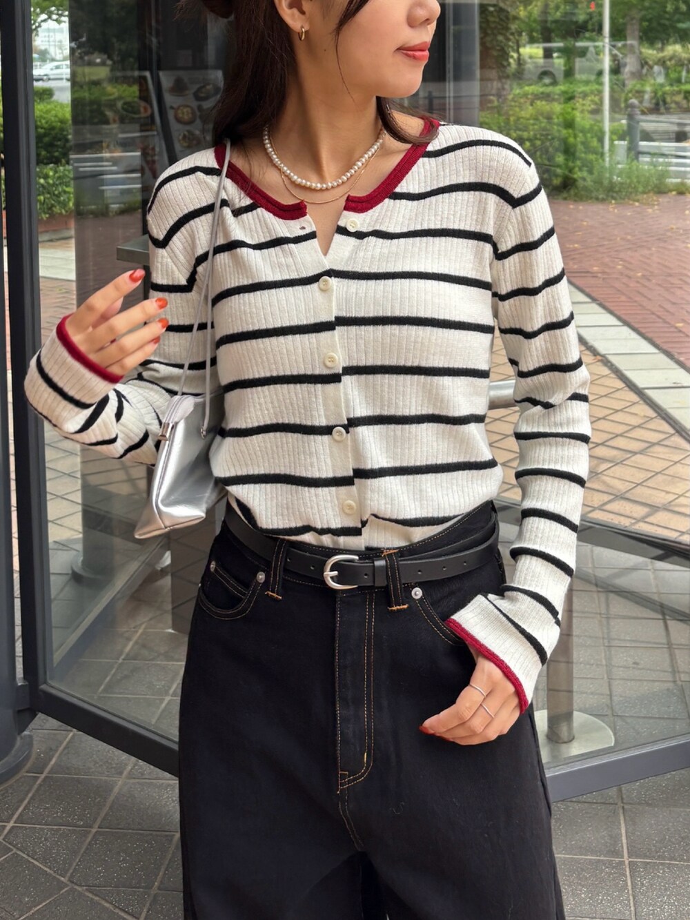 ホワイト系のカーディガン/ボレロ、ブラック系のデニムパンツを着用したレディースの秋コーディネートの2枚目の写真