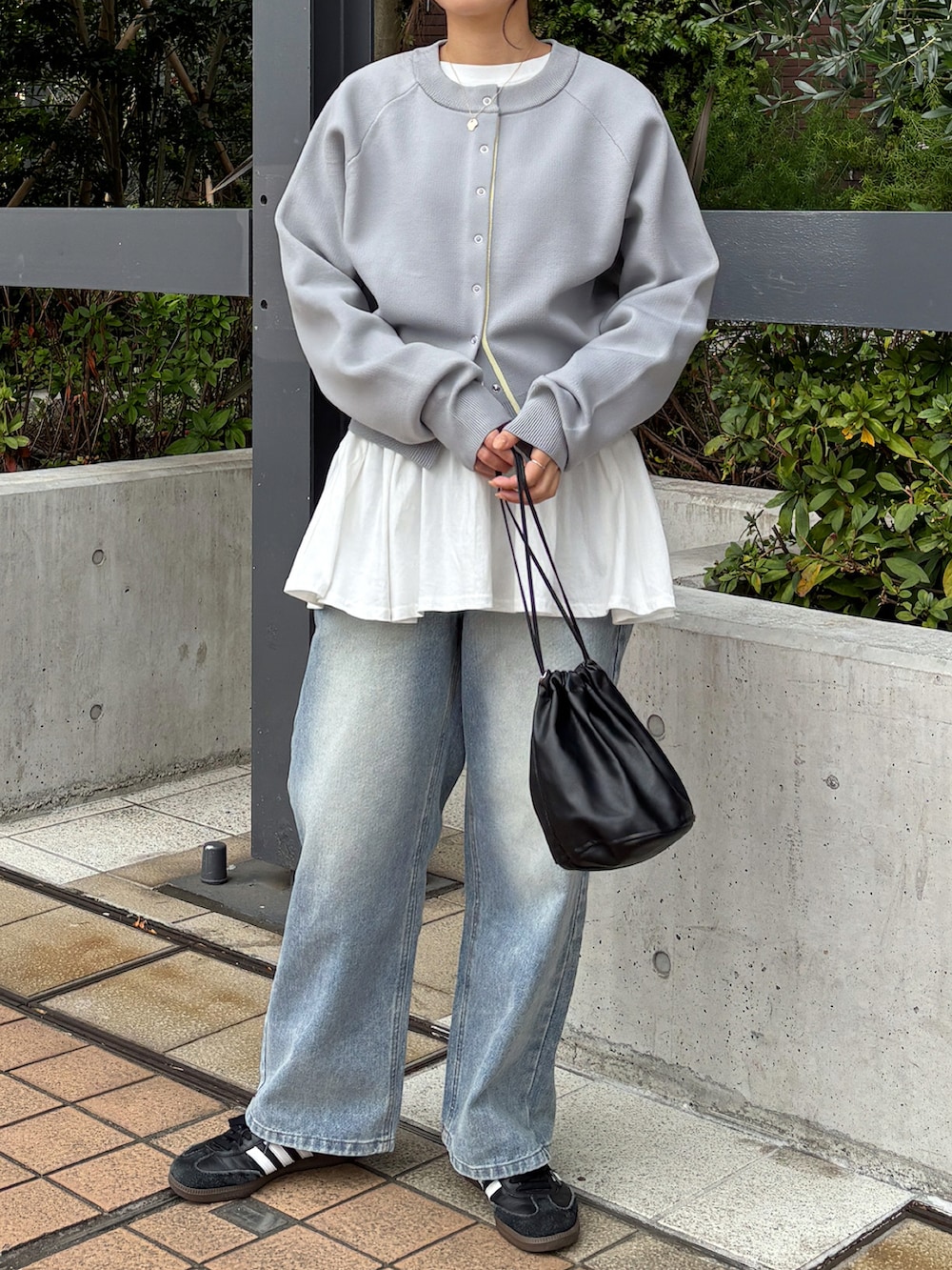 ホワイト系のTシャツ/カットソー、グレー系のカーディガン/ボレロ、ブルー系のデニムパンツを着用したレディースの春コーディネートの4枚目の写真