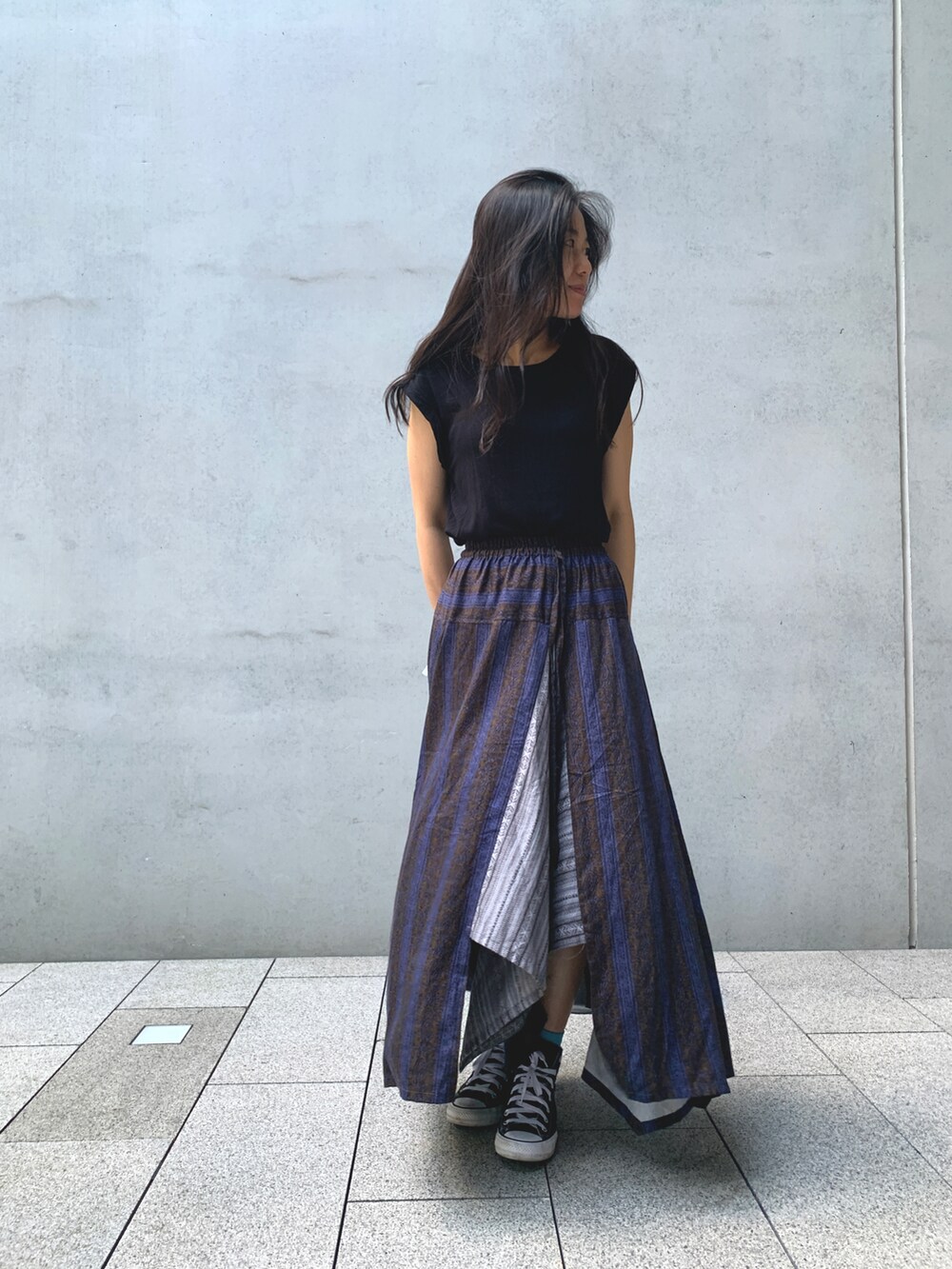 パープル系のスカートを着用したレディースの秋コーディネートの2枚目の写真