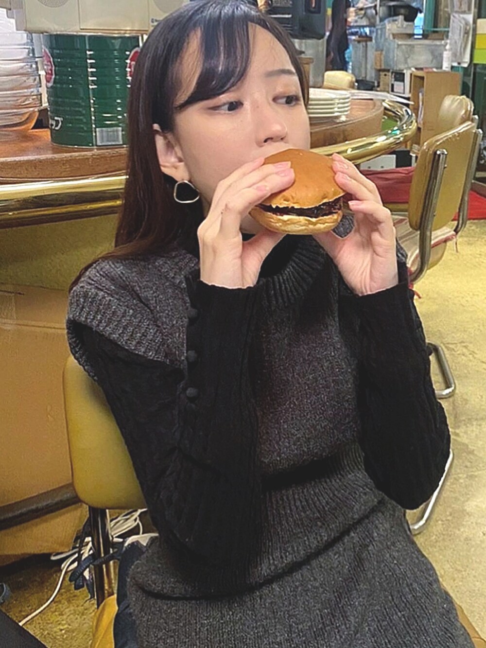 グレー系のワンピース、ブラック系のニット/セーター、ブラック系のブーツを着用したレディースの冬コーディネートの3枚目の写真