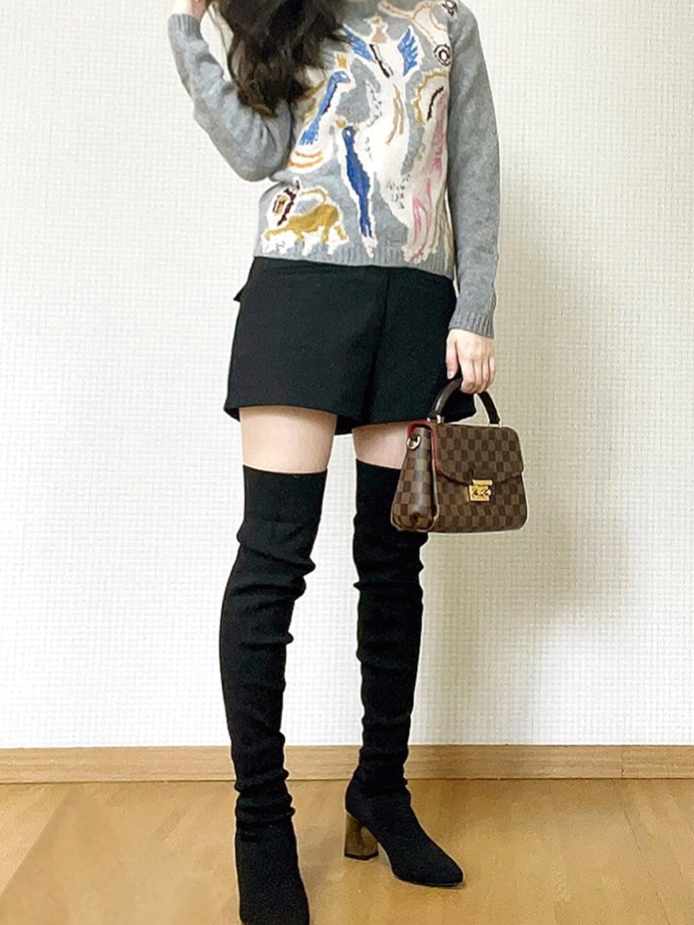 ブラウン系のハンドバッグ、グレー系のニット/セーター、ブラック系のスウェットパンツを着用したレディースの冬コーディネートの2枚目の写真