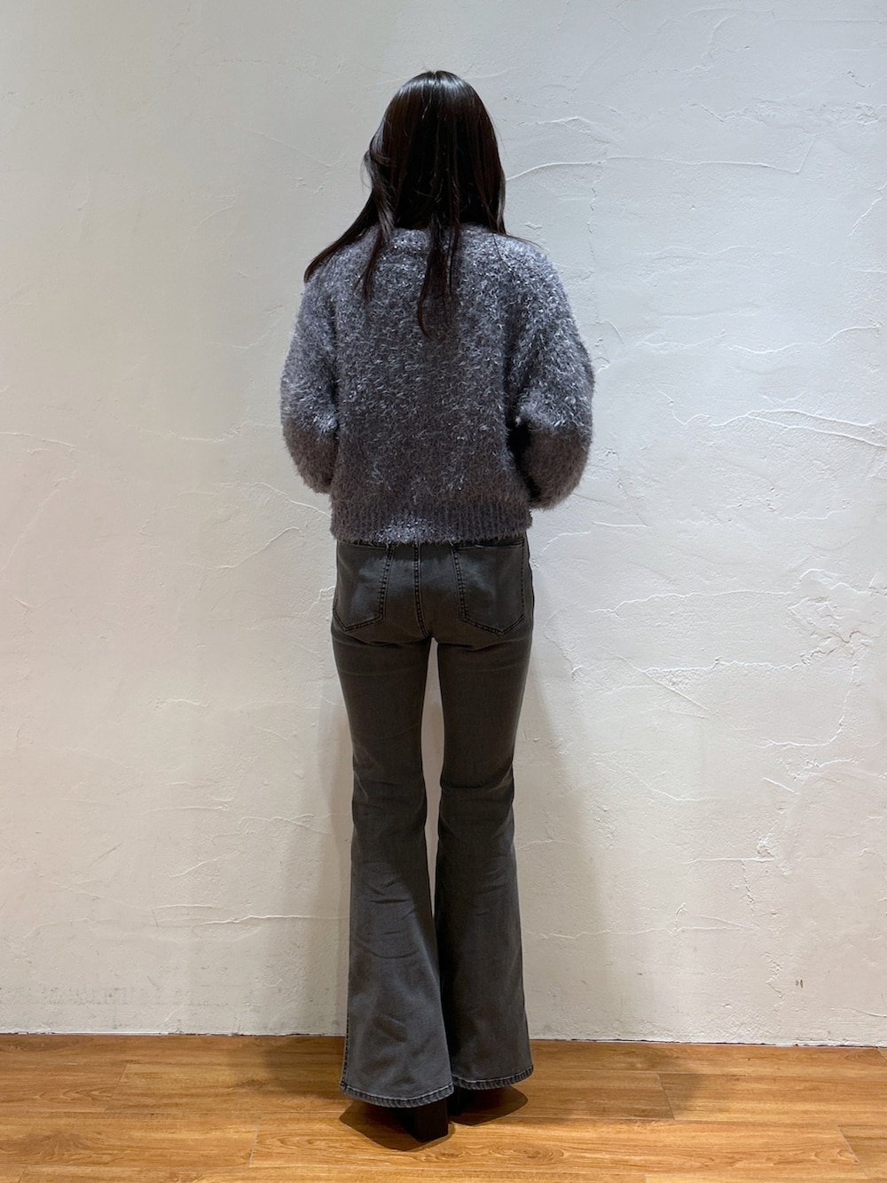 グレー系のニット/セーター、ブラック系のデニムパンツ、ブラック系のブーツを着用したレディースの冬コーディネートの3枚目の写真