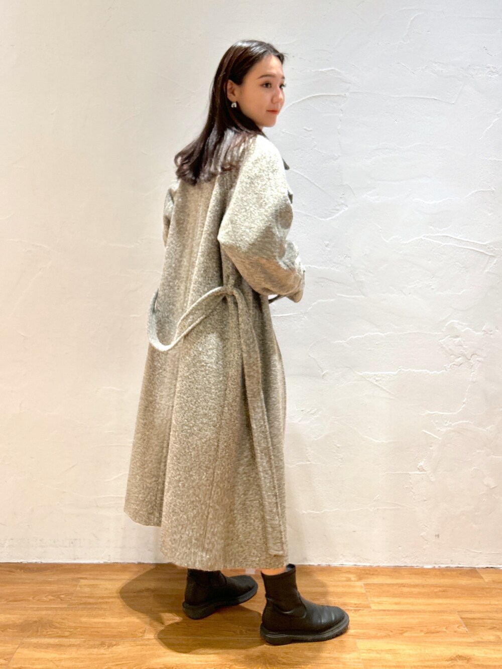 ベージュ系のステンカラーコートを着用したレディースの秋コーディネートの3枚目の写真