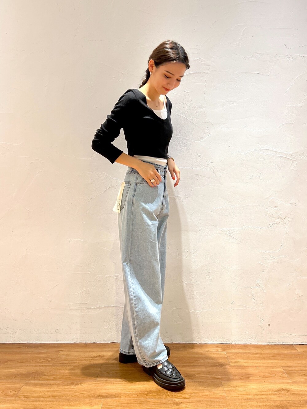 ブルー系のデニムパンツ、ブラック系のTシャツ/カットソー、ブラック系のローファーを着用したレディースの秋コーディネートの2枚目の写真