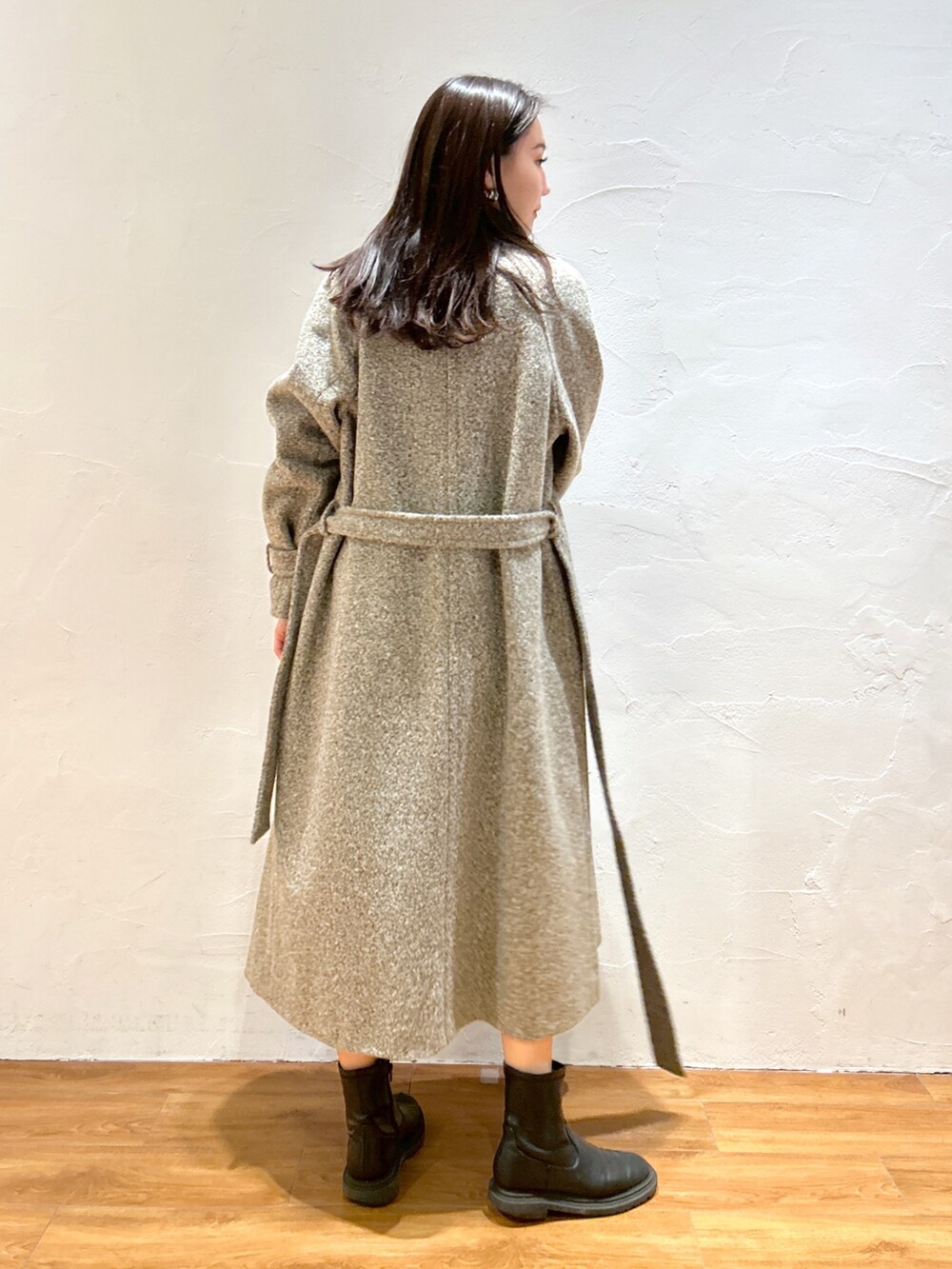 ベージュ系のステンカラーコートを着用したレディースの秋コーディネートの2枚目の写真