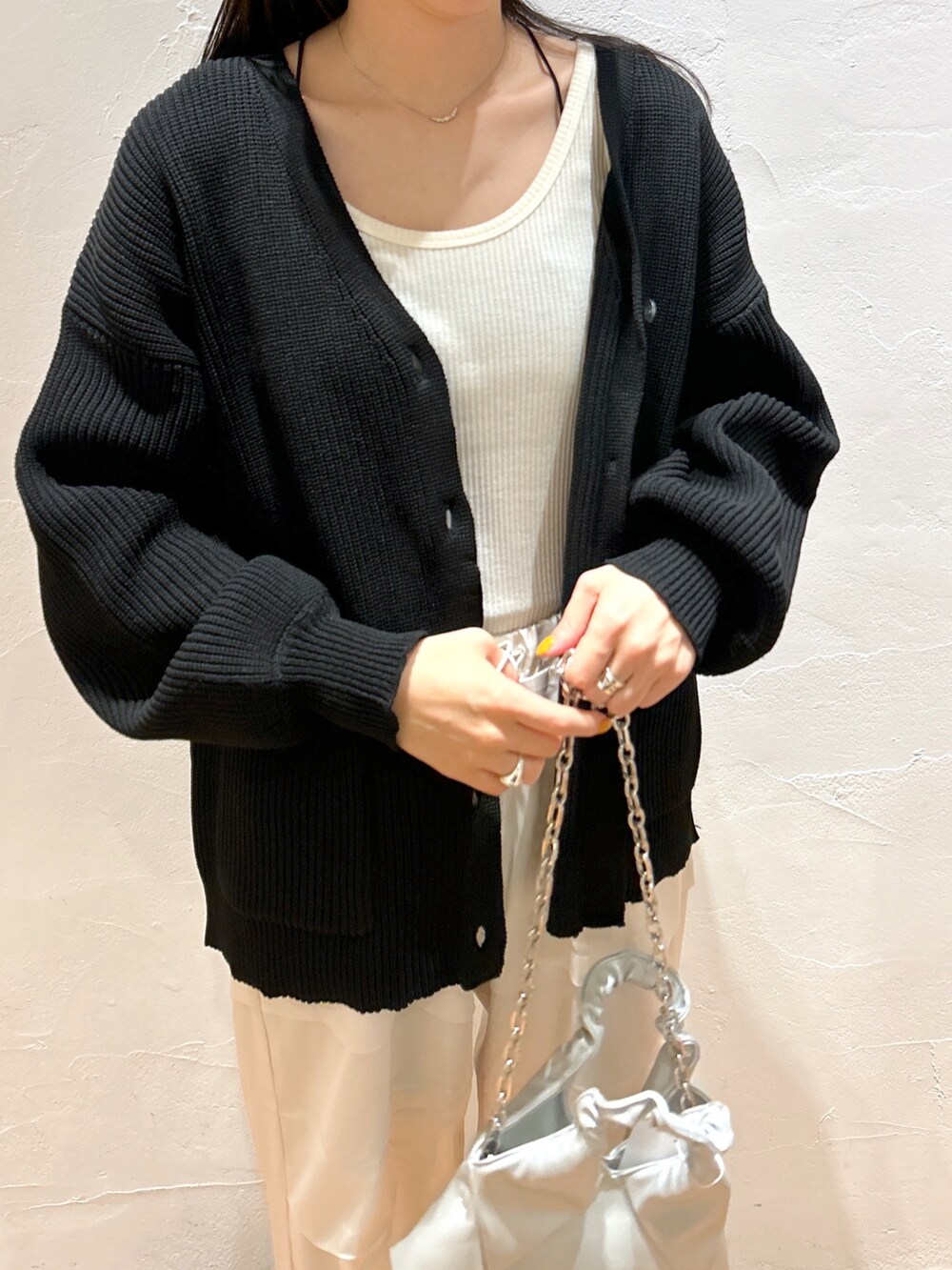 ホワイト系のカーゴパンツ、ブラック系のカーディガン/ボレロ、ブラック系のブーツを着用したレディースの秋コーディネートの4枚目の写真