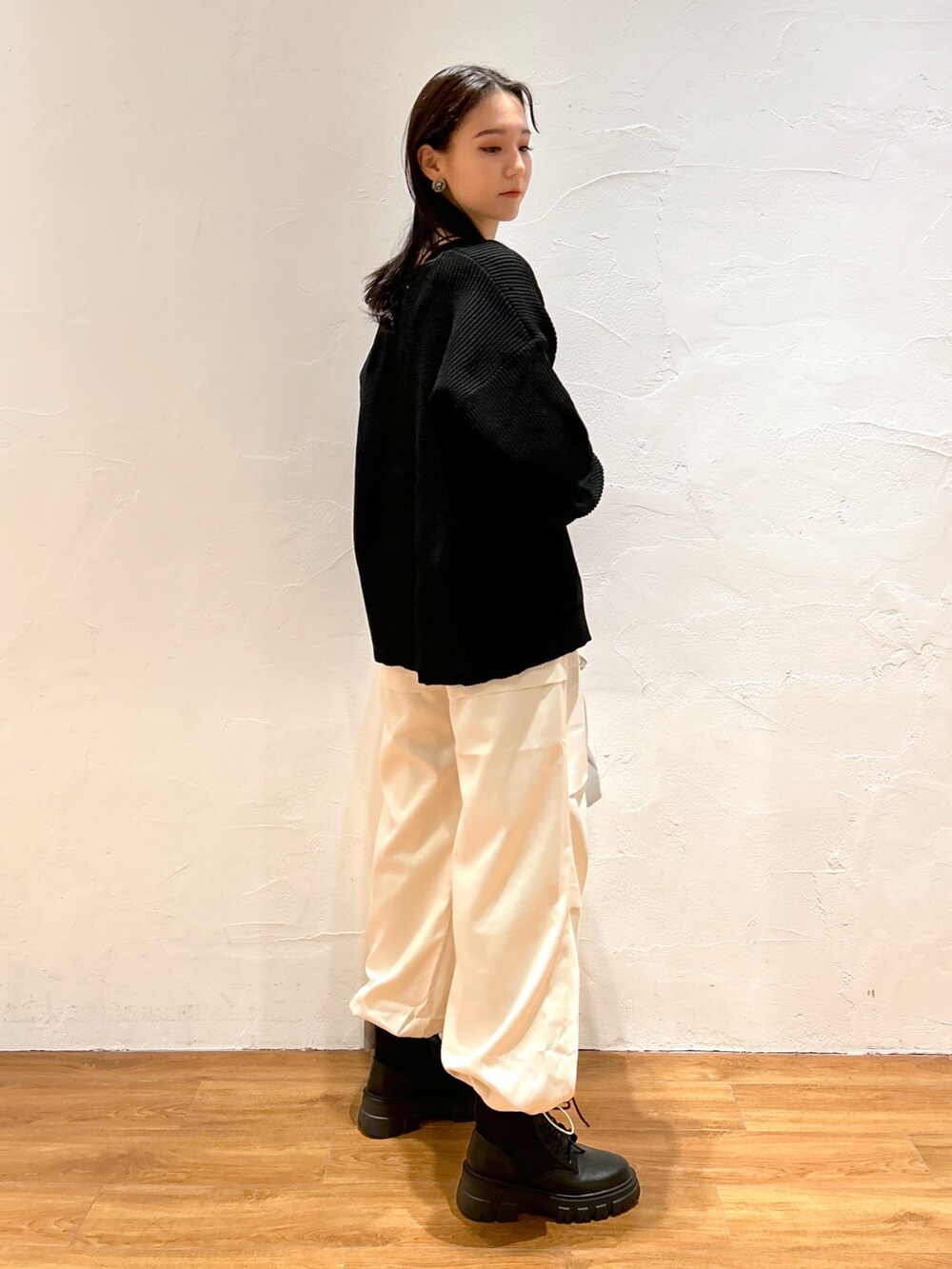 ホワイト系のカーゴパンツ、ブラック系のカーディガン/ボレロ、ブラック系のブーツを着用したレディースの秋コーディネートの2枚目の写真