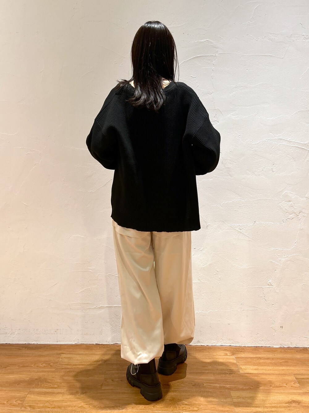 ホワイト系のカーゴパンツ、ブラック系のカーディガン/ボレロ、ブラック系のブーツを着用したレディースの秋コーディネートの3枚目の写真