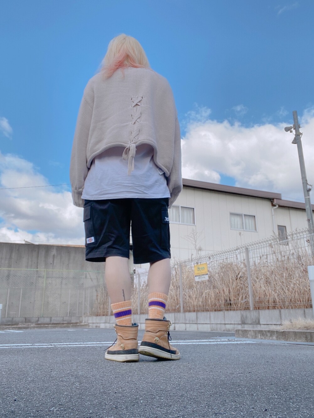 ベージュ系のニット/セーター、ホワイト系のTシャツ/カットソー、ブラック系のカーゴパンツを着用したレディースの冬コーディネートの2枚目の写真