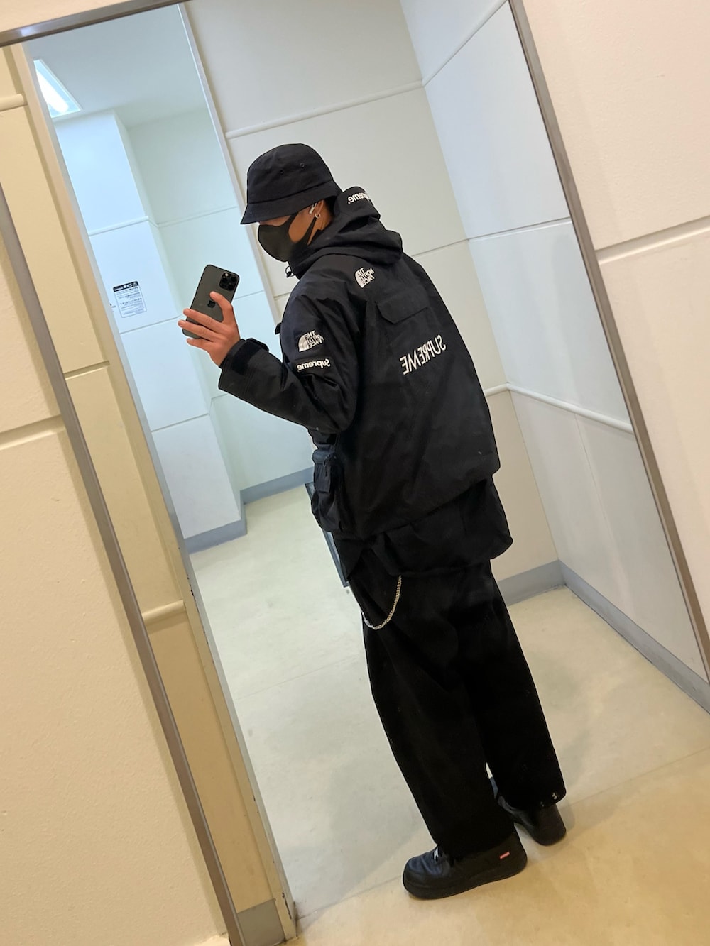 ブラック系のマウンテンパーカー、ブラック系のシャツ/ブラウス、ブラック系のスニーカーを着用したメンズの冬コーディネートの2枚目の写真