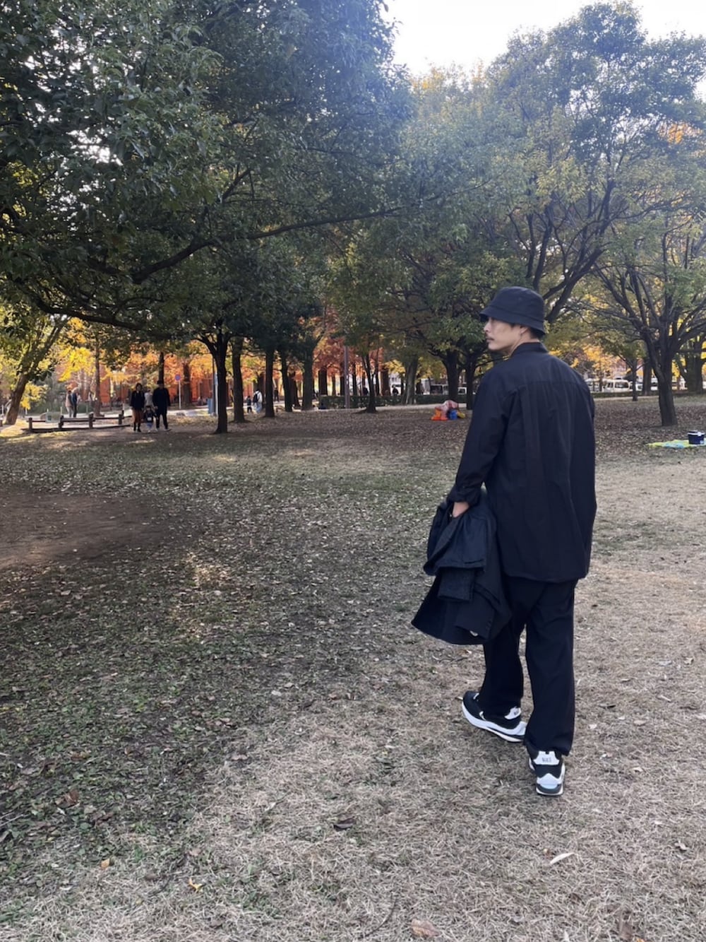 ブラック系のテーラードジャケット、ブラック系のその他パンツ、ブラック系のスニーカーを着用したメンズの秋コーディネートの2枚目の写真