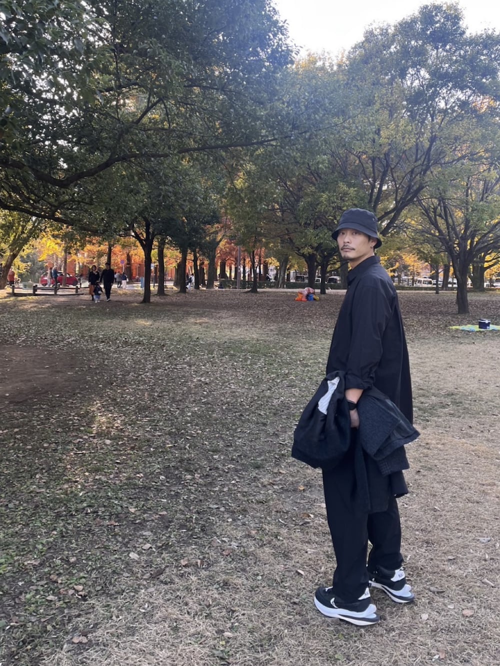 ブラック系のテーラードジャケット、ブラック系のその他パンツ、ブラック系のスニーカーを着用したメンズの秋コーディネートの3枚目の写真