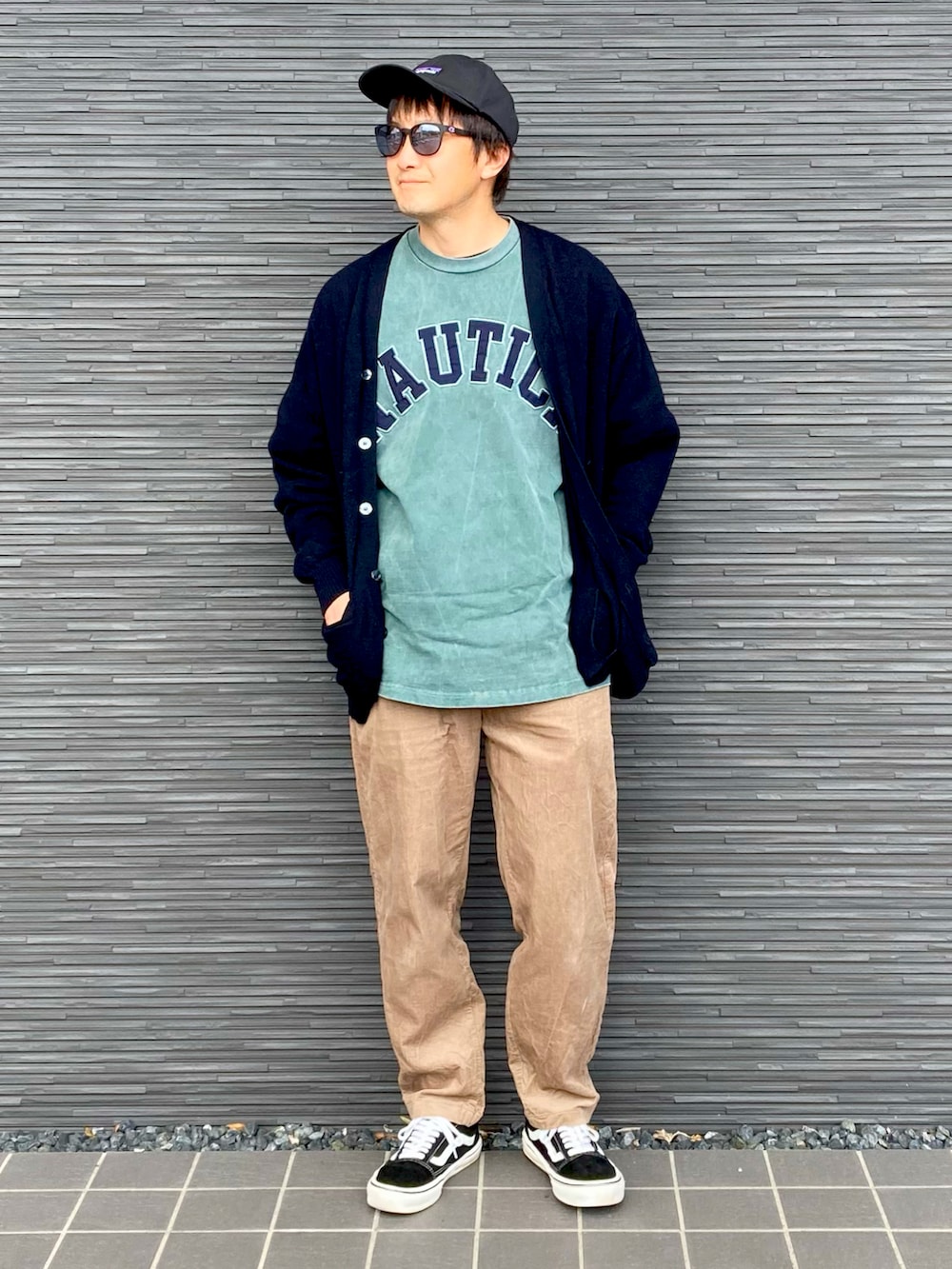 ブラック系のトップス、グリーン系のTシャツ/カットソー、ブラウン系のその他パンツを着用したメンズの春コーディネートの2枚目の写真