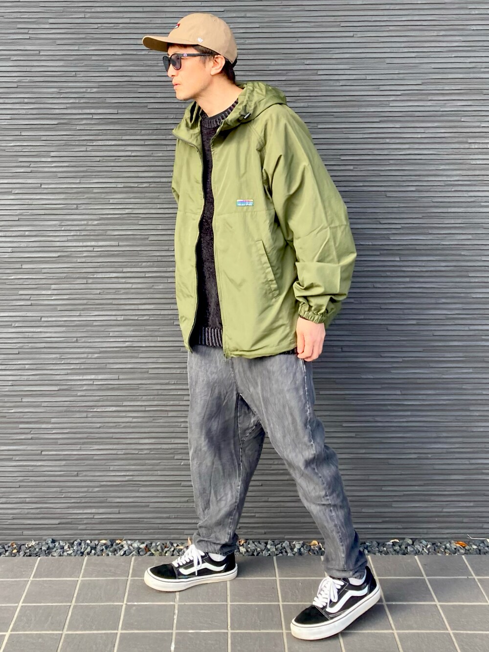 グリーン系のナイロンジャケット、ブラック系のニット/セーター、ブラック系のその他パンツを着用したメンズの春コーディネートの4枚目の写真