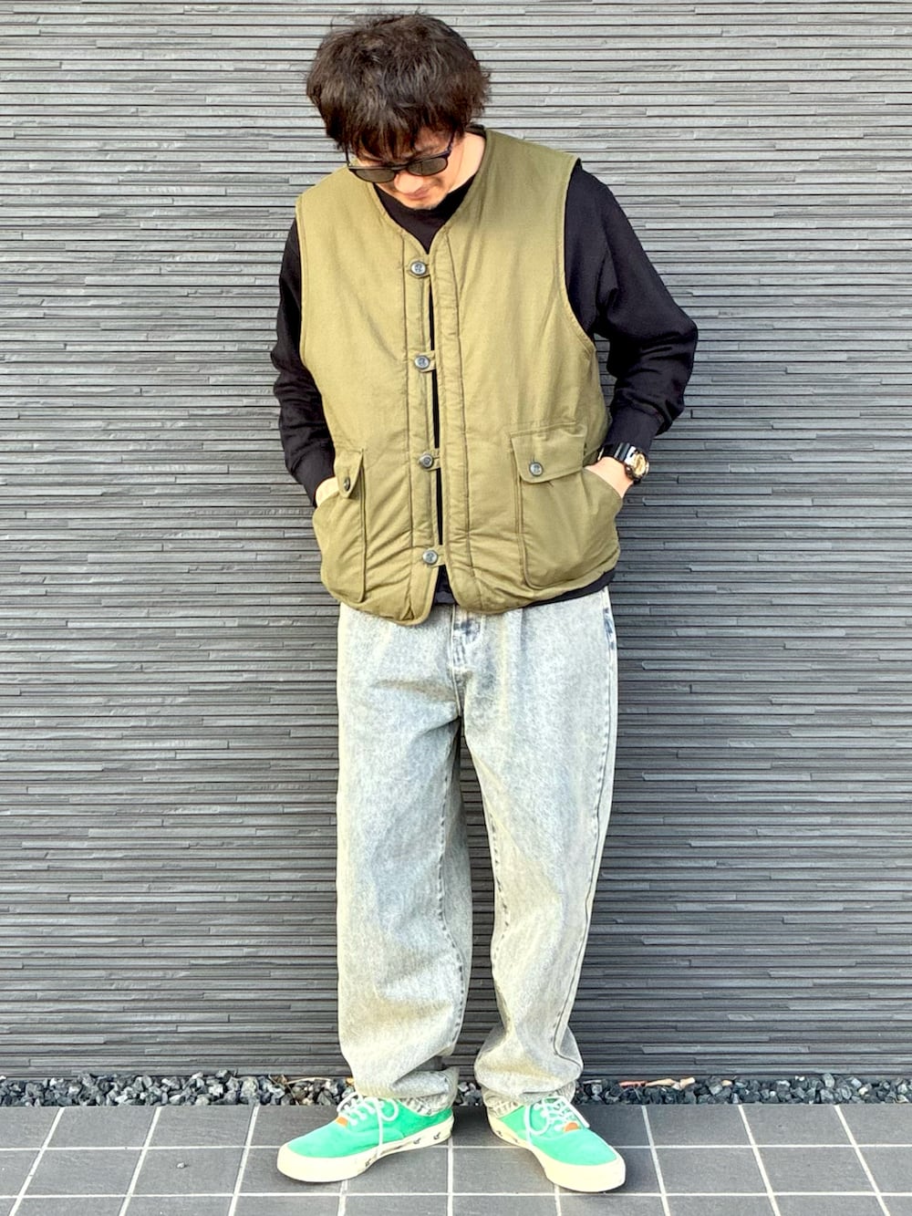 グリーン系のその他アウター、ベージュ系のその他パンツ、ブラック系のトップスを着用したメンズの春コーディネートの2枚目の写真